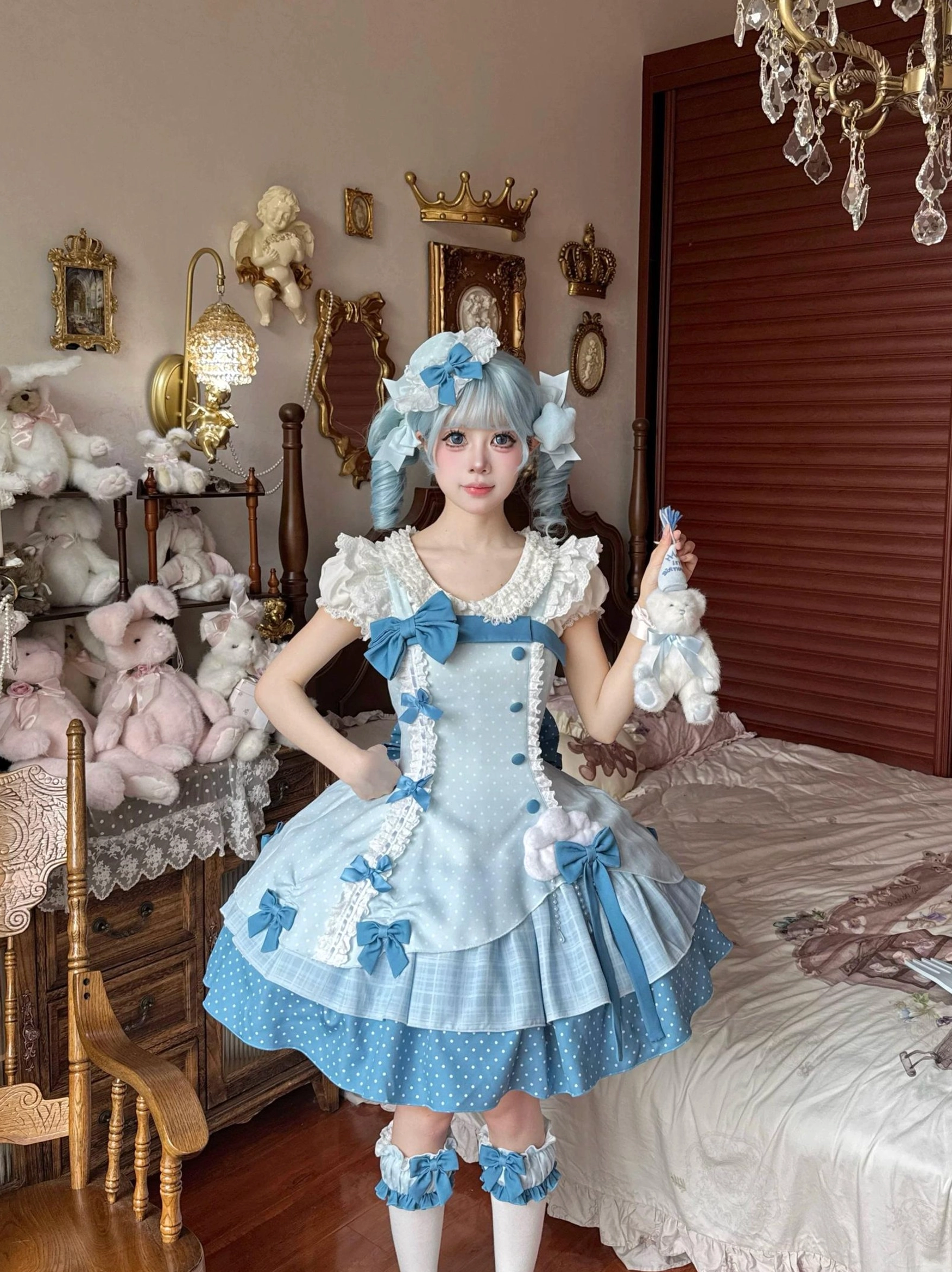 Full Sweet Lolita coordinate worn by model front full-body shot in vintage plush toy bedroom, wearing complete set with JSK dress, matching hat, leg garters, and blue twin-tails hair accessories, holding plush rabbit prop