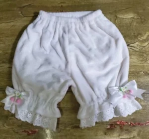 White satin bow coral fleece Lolita bloomers overhead flat lay display with dual pink berry and flower ornaments on scalloped eyelet lace leg cuffs and elastic shirring