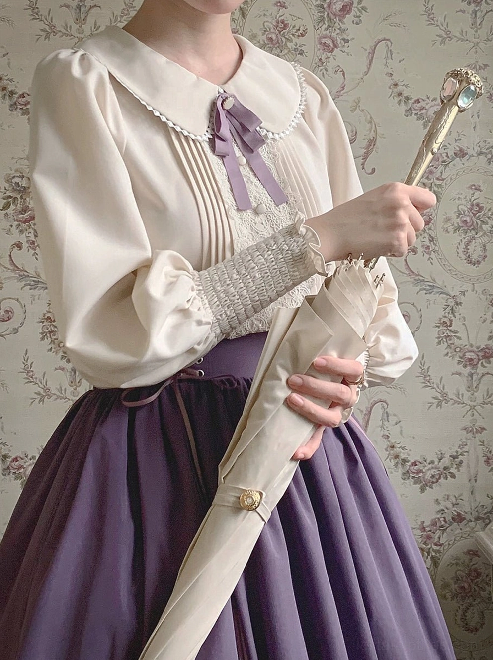 Vintage lolita blouse and high-waisted skirt close-up detail shot showing bishop sleeves lace trim and bow with vintage accessories