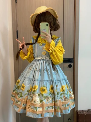 Country lolita JSK dress with cat and sunflower prints worn by model with twin brown braids and straw sunhat in mirror selfie indoors