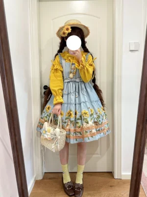 Full body view of cat and sunflower country lolita dress paired with yellow ruffled blouse, white woven basket bag, crew socks and brown loafers