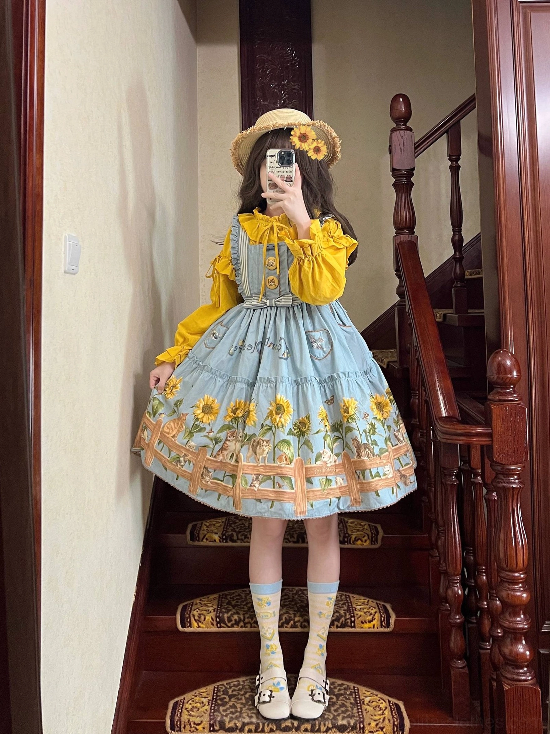 Full body front view of cat and sunflower lolita JSK dress on staircase with white ruffled socks and round-toe flats coordination