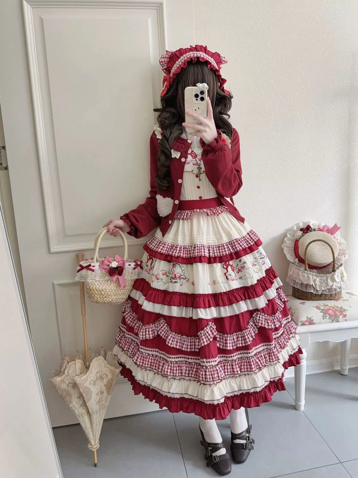 Country lolita jumper skirt side view model wearing burgundy coat bonnet and strawberry embroidered tiered skirt
