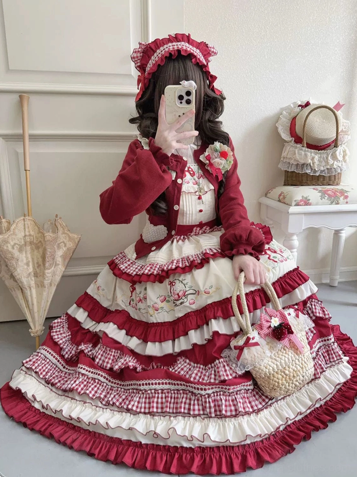 Country lolita coordinate with burgundy cardigan wide tiered gingham trimmed jumper skirt strawberry motif low angle view