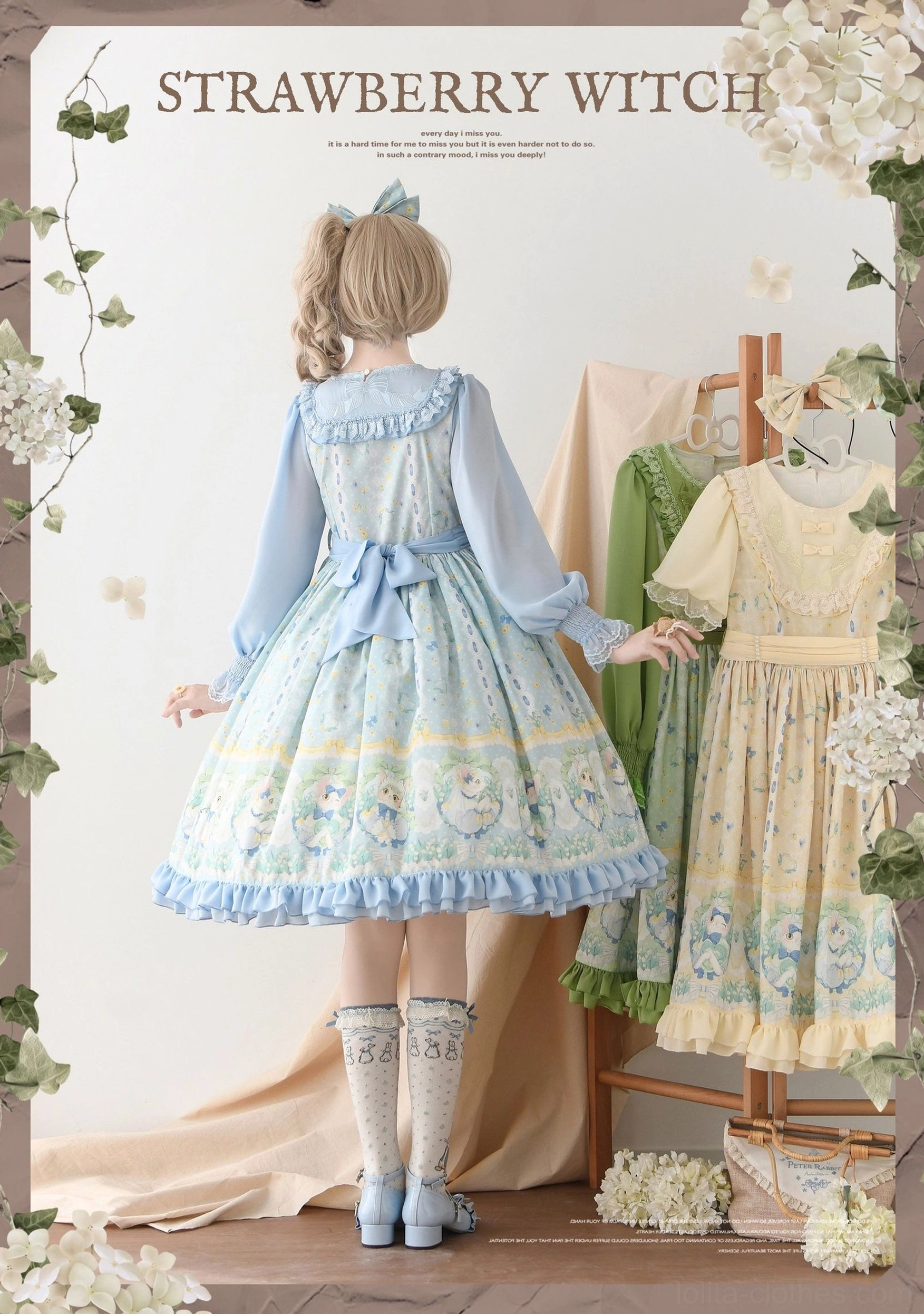 Blue long-sleeve country lolita OP dress with back waist bow and cat prints, rear view on model wearing printed socks, showing ruffled sleeves and hem details
