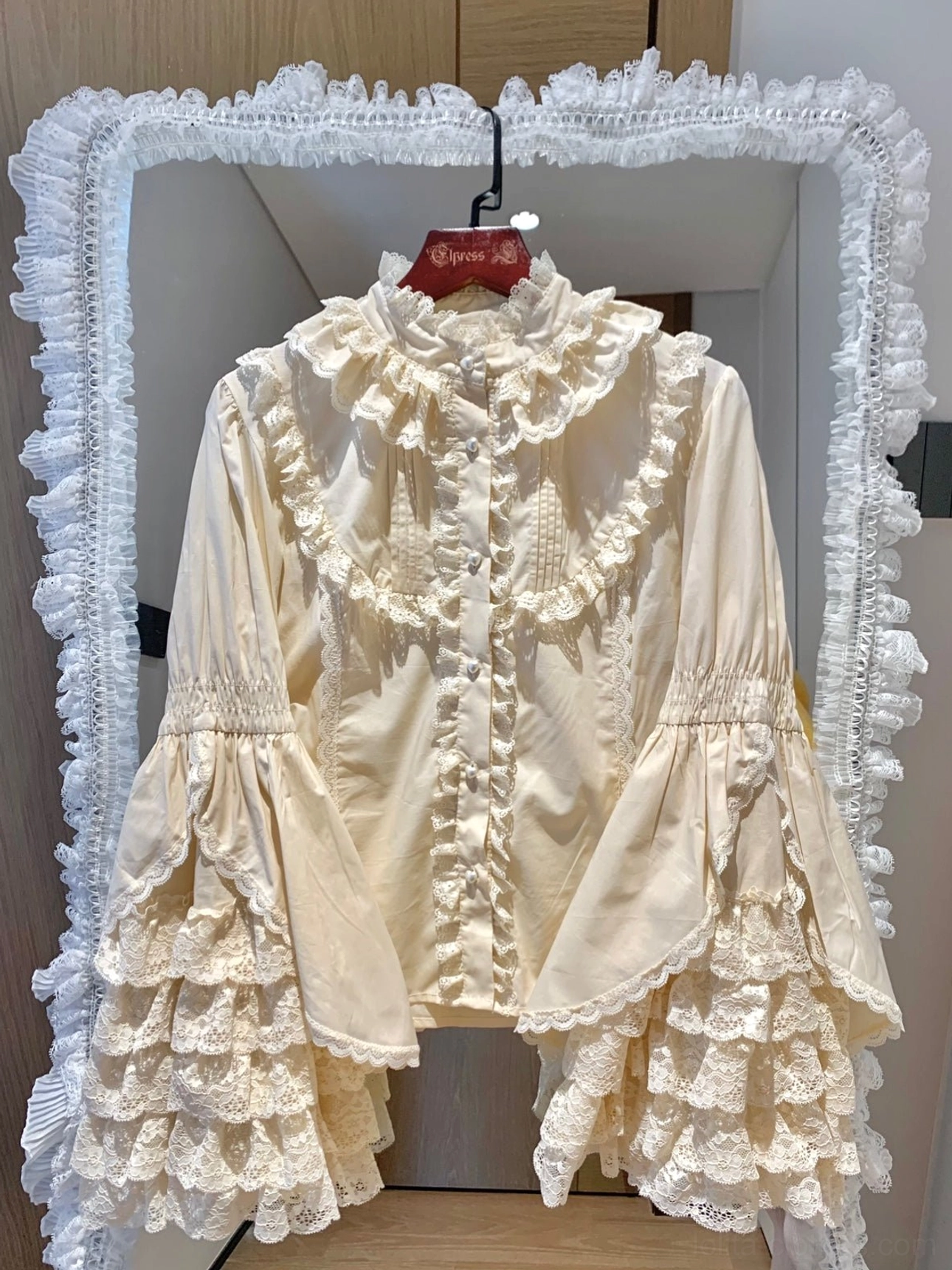 Cream beige Lolita princess blouse featuring tiered lace trumpet sleeves and ruffled stand collar