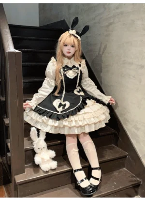 Cream Bud tiered hem old school lolita JSK black colorway front three-quarter seated view with stairwell backdrop and plush rabbit prop