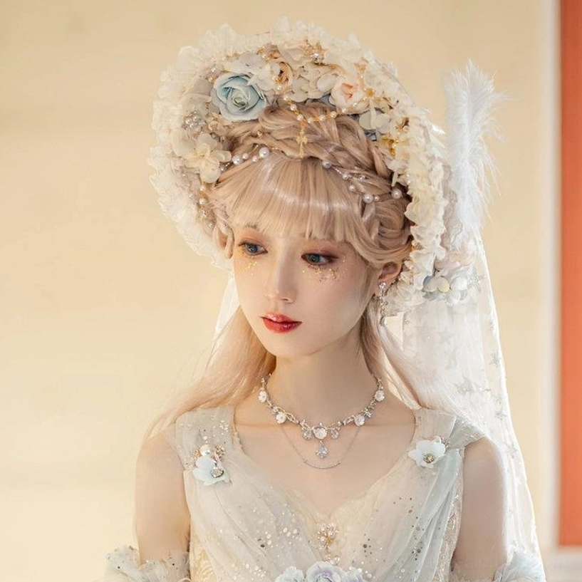 Cream floral Lolita bonnet hat with bridal veil, blue roses, gold cross ornament, and star-patterned veil on dress form back view