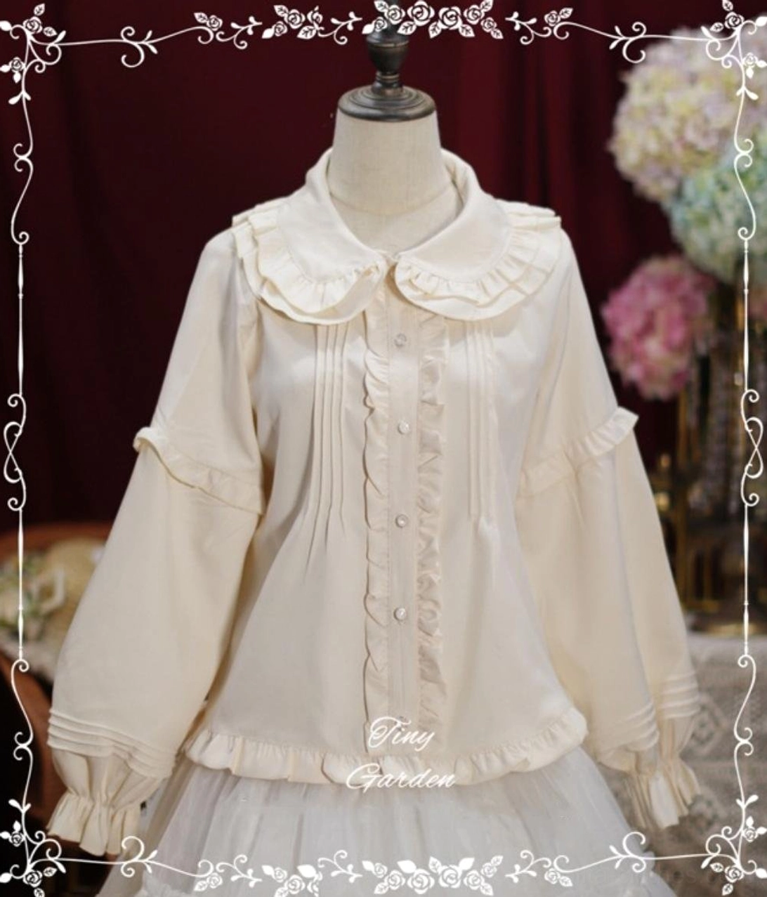 Cream off-white long-sleeve Lolita blouse featuring classic ruffled collar, front pin-tuck and ruffle trim, flared ruffled sleeves on mannequin