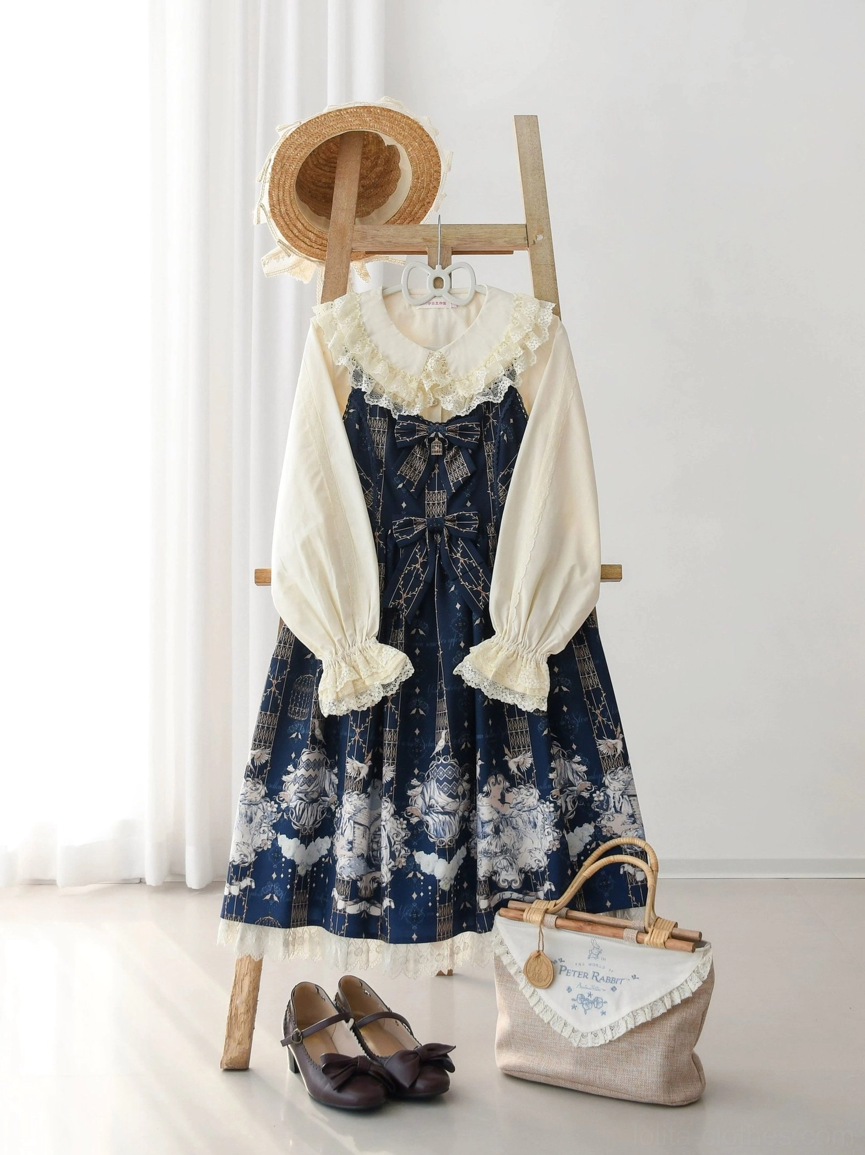 Full body mannequin wearing cream Lolita blouse with navy star print JSK dress, displayed with wooden ladder prop, straw hat, leather shoes and coordinating accessories for classic daily Lolita look