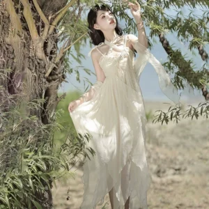 Cream lolita summer JSK dress with ruched bust and long chiffon sash - side full-body view at woodland lakeside showing lightweight flowy fabric and elegant drape