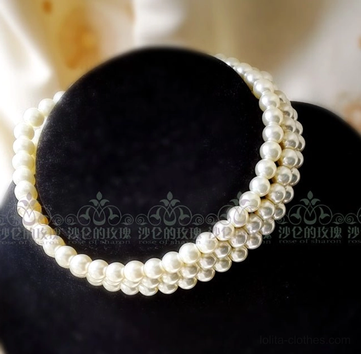 Single-strand cream pearl choker close-up view on black velvet neck mannequin, displaying uniform round faux pearls in classic simple layered choker style