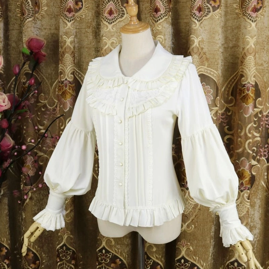 Cream white classic Lolita Peter Pan collar blouse with detailed ruffled collar, front vertical pleats and ruffled sleeve cuffs, three-quarter view
