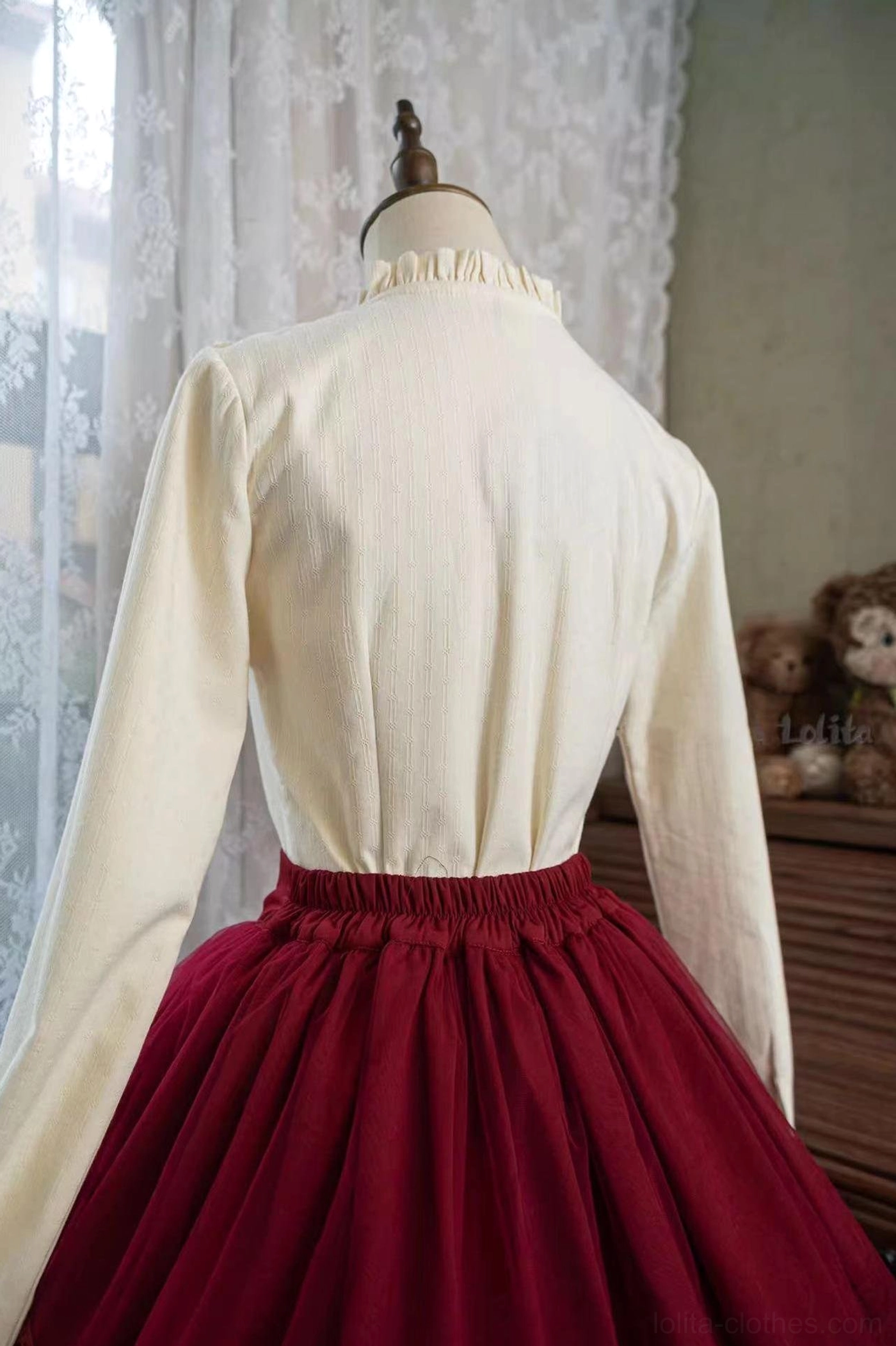 Cream yellow fleece-lined lolita blouse back view on dress mannequin paired with burgundy skirt showing stand collar and ribbed woven fabric texture