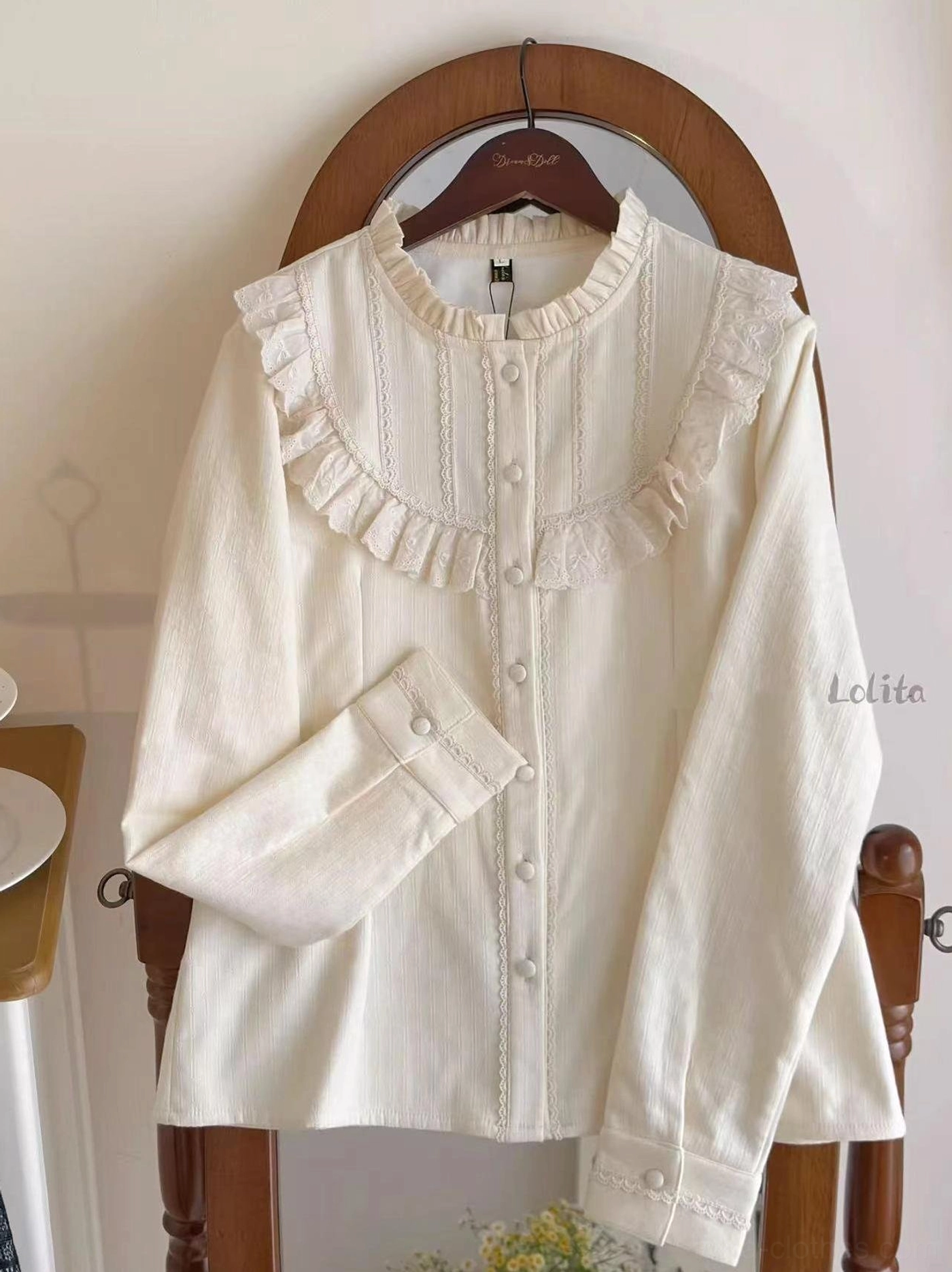 Cream yellow daily lolita fleece blouse front flat display on hanger with ruffled stand collar and lace detailed front placket vintage indoor home setting