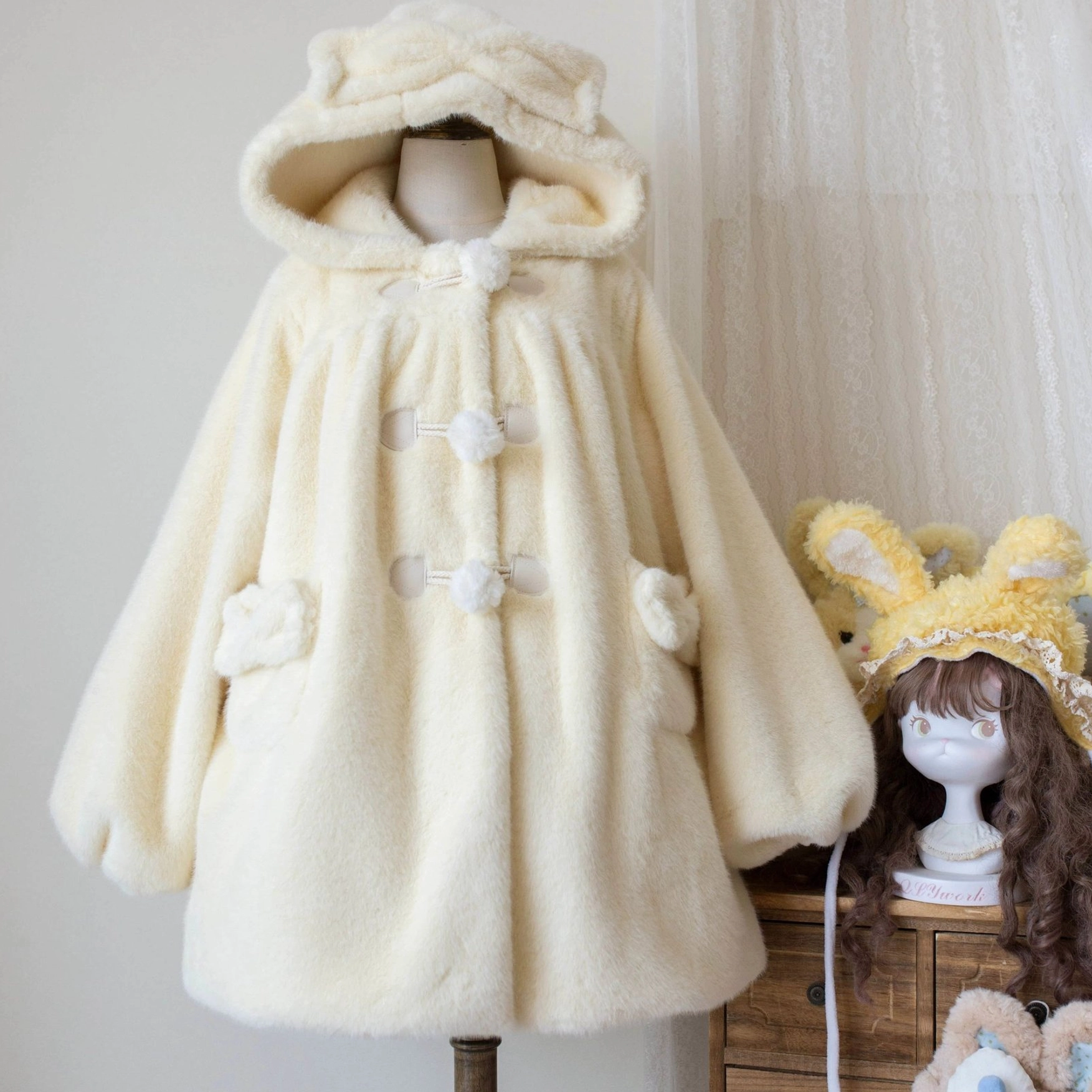 Cream yellow lolita winter thickened fluffy overcoat front display on mannequin showing bear ear hood, pom-pom toggle buttons, side patch pockets and oversized silhouette