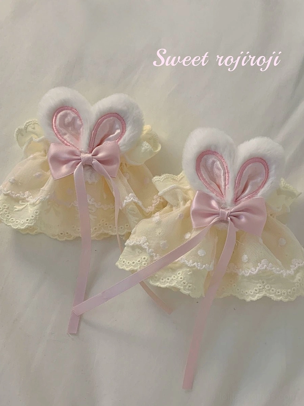 Cream yellow polka dot lace rabbit ear wrist cuffs pair flat lay with plush bunny ears and ribbon tails