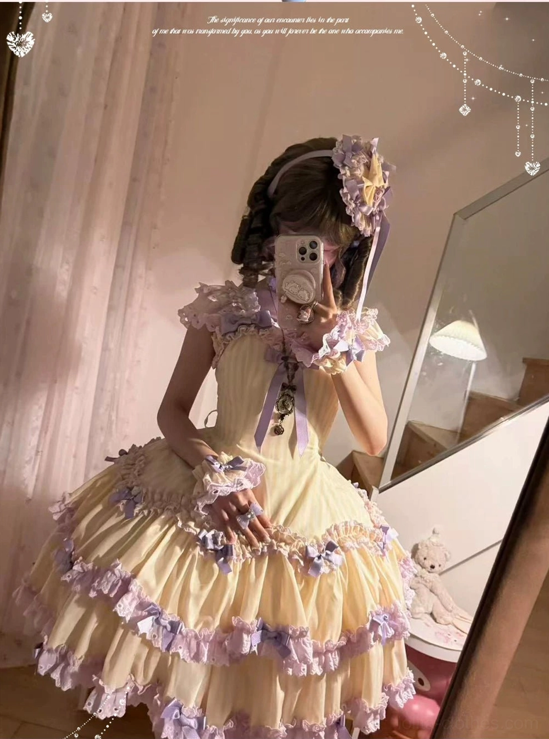 Cream yellow and purple striped Lolita dress detail view showing bust bow, ruffled skirt construction, and decorative bow ornaments