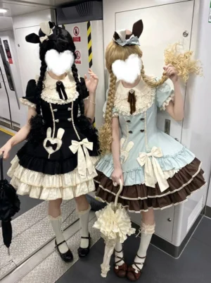 Front full-body view of creamy bunny heart old school lolita op dress in mint blue and pink colors with tiered ruffled skirts and heart bunny embroidery on two models in boutique setting