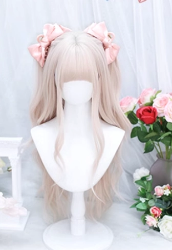 Soft creamy pink wavy lolita wig with elegant air bangs on mannequin, styled with pink satin bows, white floral romantic backdrop photography
