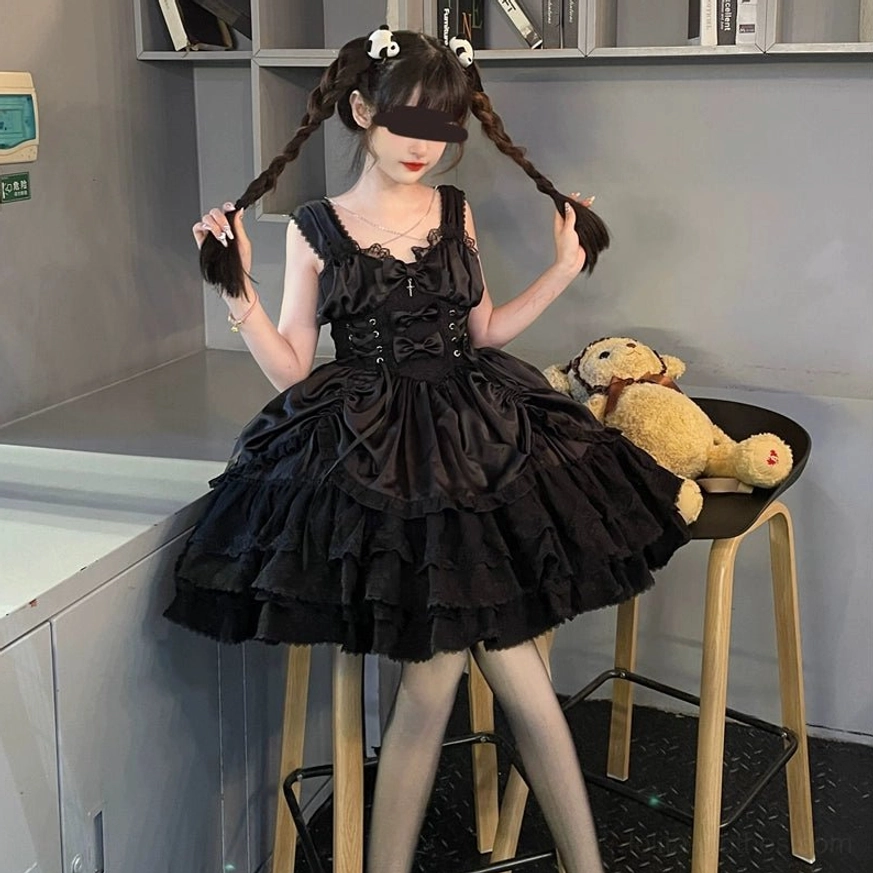 Cross Medal Gothic Lolita JSK dress worn with twin braids hairstyle and teddy bear prop, showing front-side perspective of lace-up waist and ruffled skirt layers