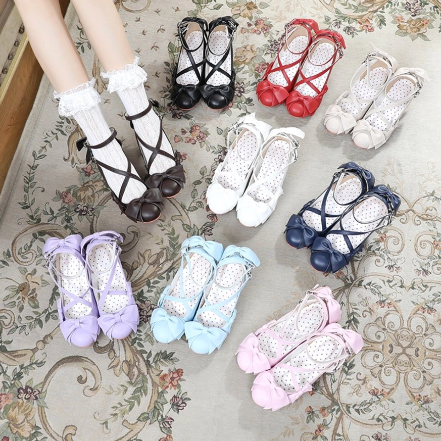 Full color set of nine cross-strap sweet Lolita Mary Jane high heels shown in top-down flat lay arrangement on vintage floral carpet, displaying all available color variants with cross-strap design and bow ornament