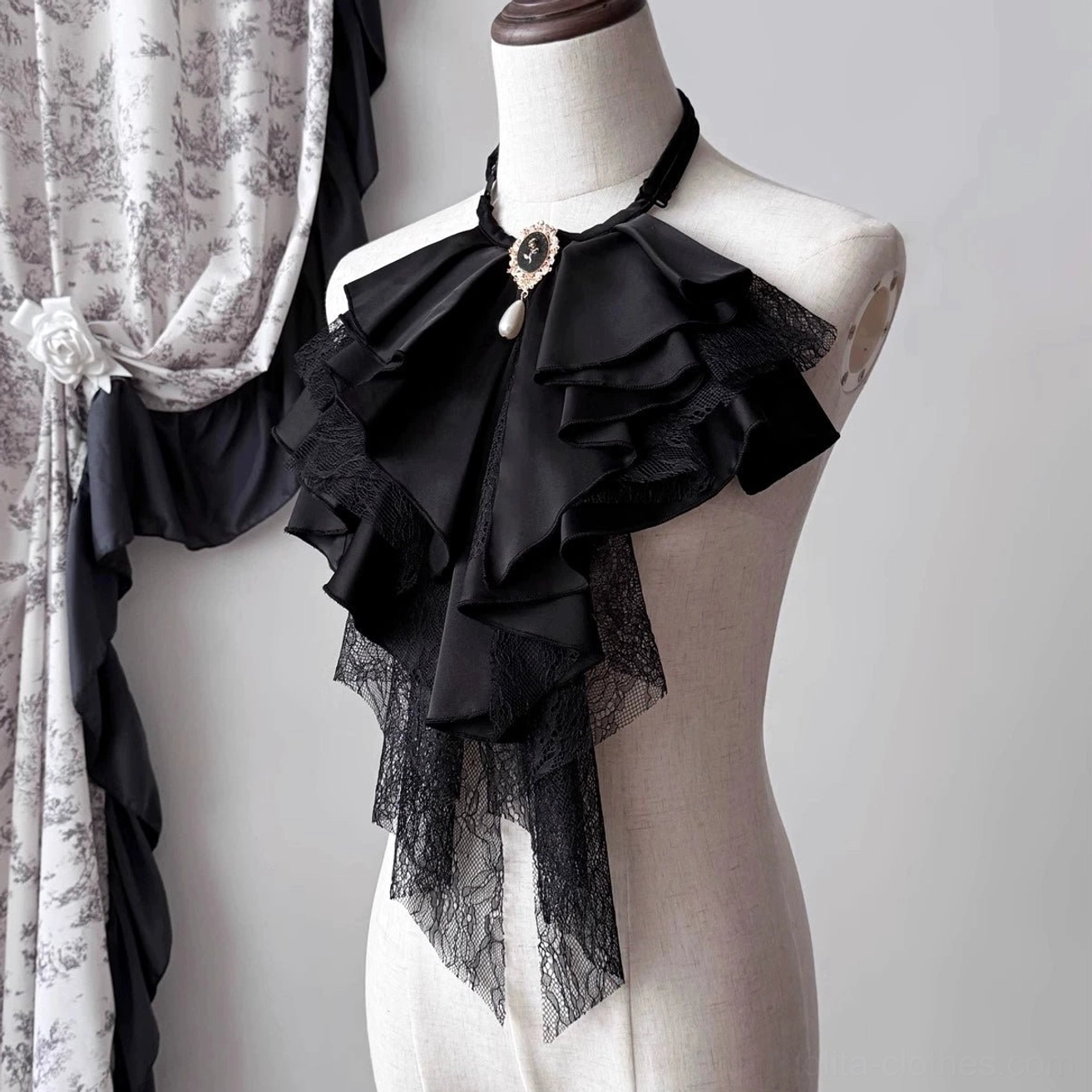 Black Gothic Lolita detachable jabot shown from an angled front view, with layered ribbon ruffles, lace hanging trim, and ornamental vintage brooch