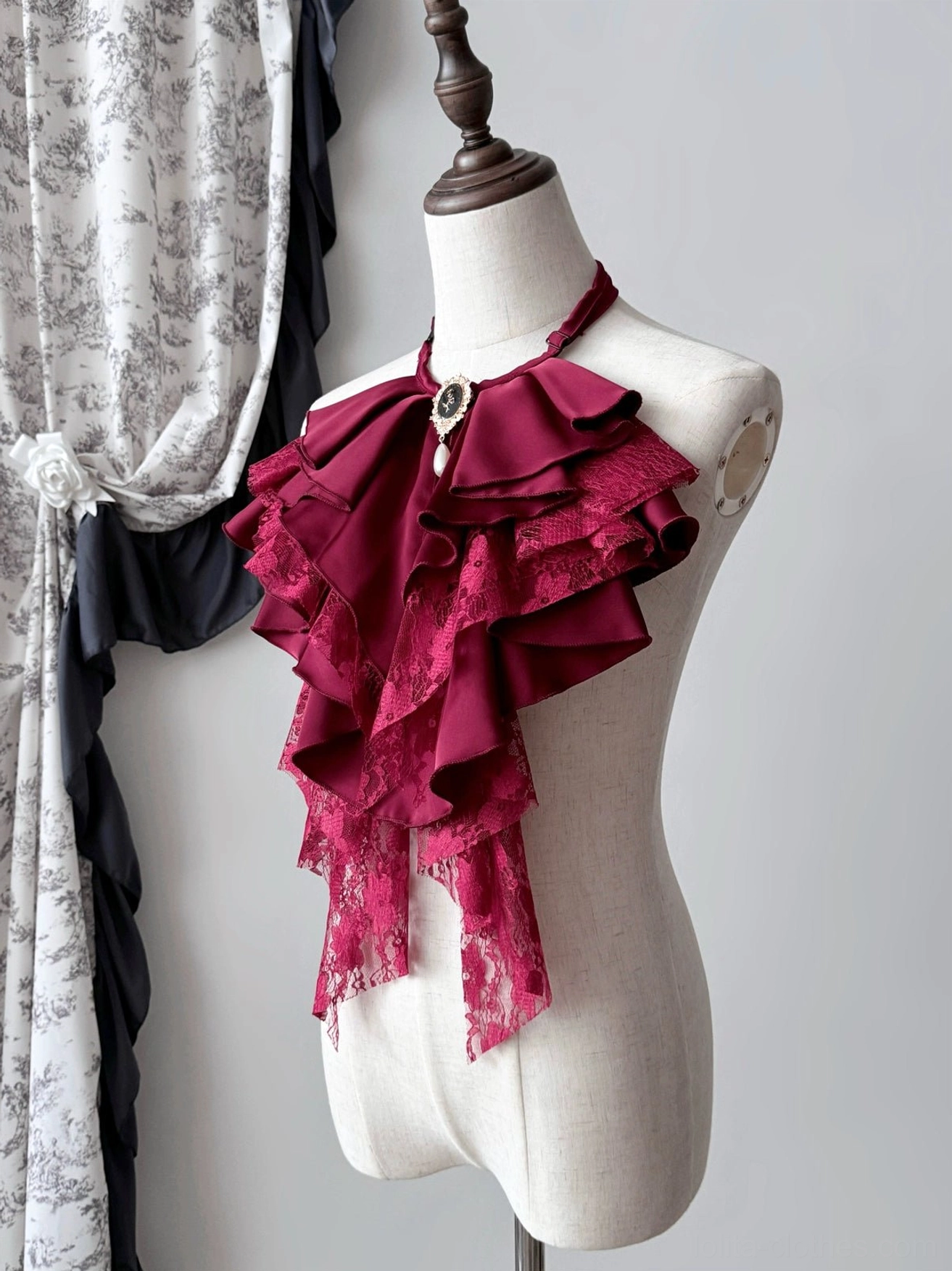 Dark red Gothic Lolita ruffle jabot displayed at an angle on a mannequin, featuring lace edging and a detachable vintage-style gemstone brooch