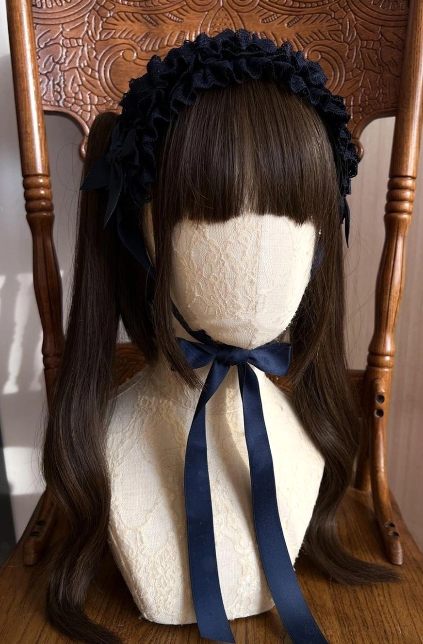 Cyan lace KC headdress flat lay product shot from overhead, displaying cool blue tone ruffled lace with satin bow and decorative ribbon elements