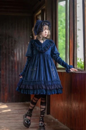 Dark blue gothic lolita OP dress with leg-of-mutton sleeves and multi-layer ruffled skirt, modeled indoors with matching bonnet and platform shoes