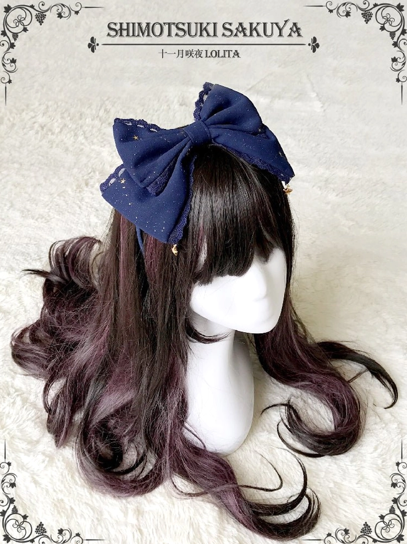 Dark blue navy vintage Lolita bow KC hair accessory with tiny star charm pendants shown on display mannequin against fluffy backdrop
