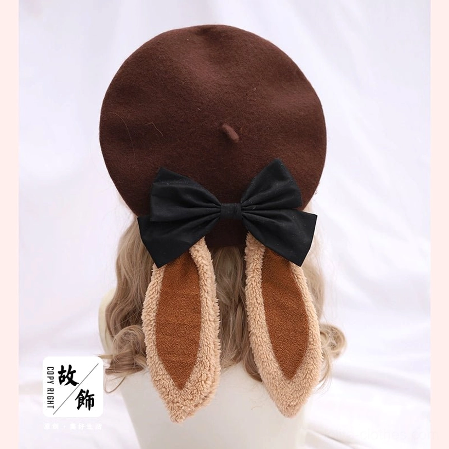 Dark brown lolita beret with beige fuzzy trimmed bunny ears and black bow accent - rear flat lay mannequin display