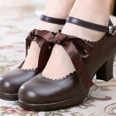 Dark brown lolita Mary Jane high heel shoes with cross brown ribbon bow, scalloped shoe edge, ankle buckle strap, glossy leather surface on floral patterned carpet background