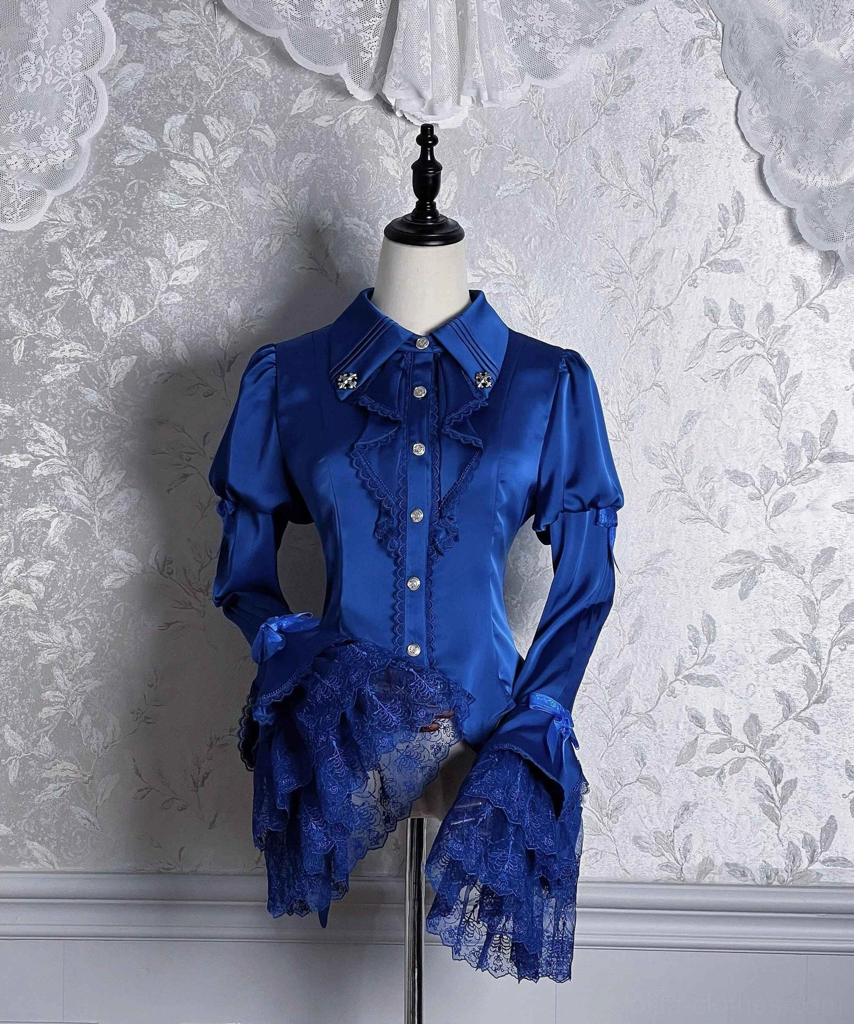 Dark Fog Feast Gothic Lolita satin blouse front view with royal blue color, hime sleeves, pointed collar, decorative bow cuffs, and asymmetrical hem on dress form