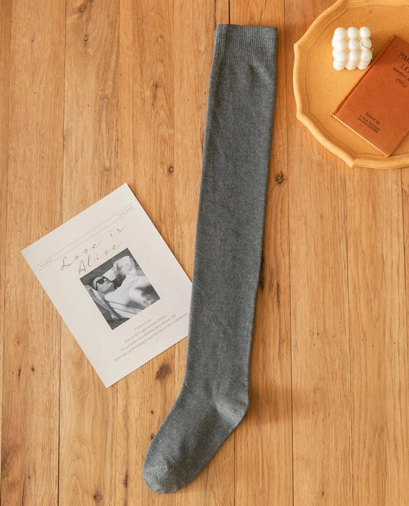 Single dark gray heather lolita cotton knee stocking flat lay wooden table decorative props soft knitted finish