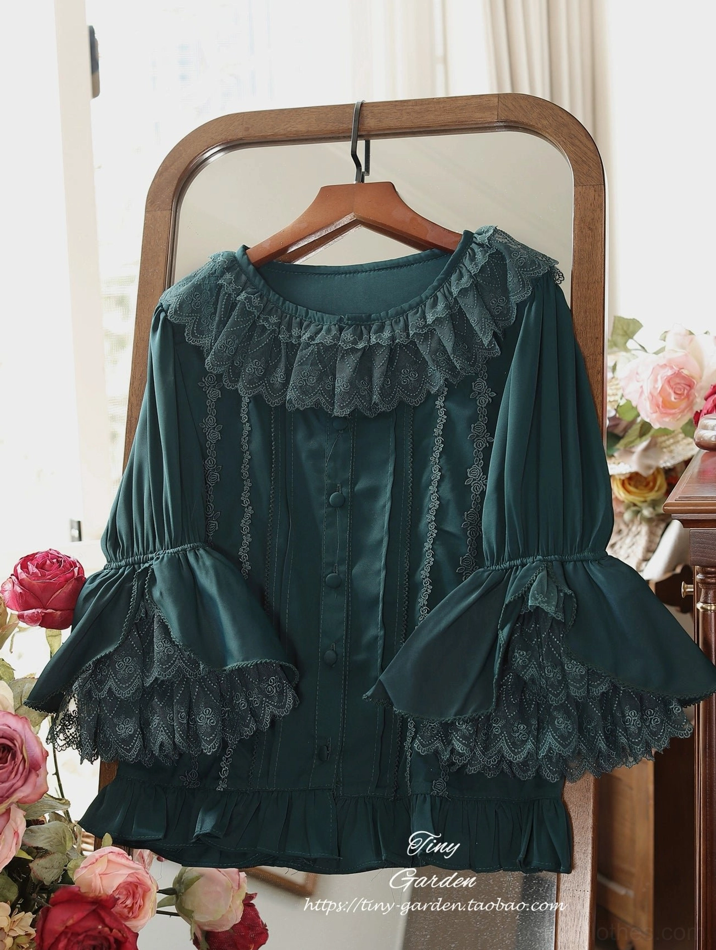 Dark green vintage ruffled lolita blouse with lace ruffled collar and multi-layered bell sleeves, hanging front display with retro mirror and flower background, delicate lace detailing