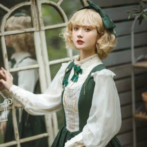 Dark green lolita head bow KC and dress coordinate with ruffled white blouse and green vest worn by blonde bob wig model at wooden window