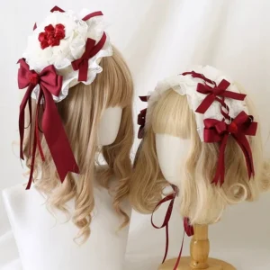 Dark red lolita hairband with white ruffled lace and wine-red satin bows displayed on dual blonde wig mannequin heads showing multiple styling angles