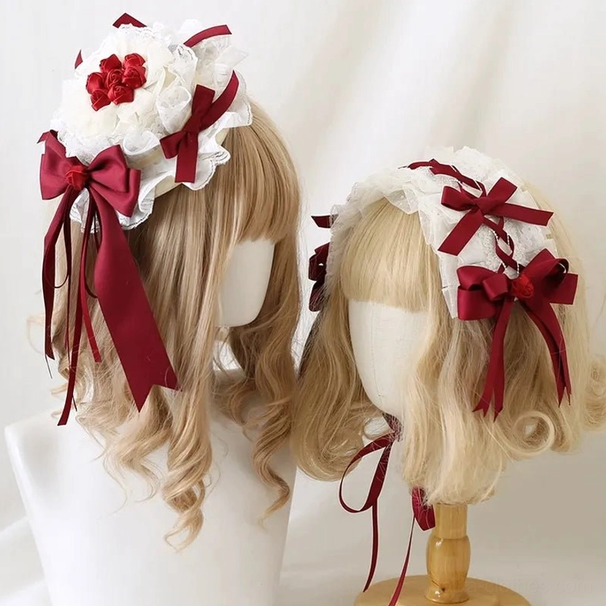 Dark red lolita hairband with white ruffled lace and wine-red satin bows displayed on dual blonde wig mannequin heads showing multiple styling angles