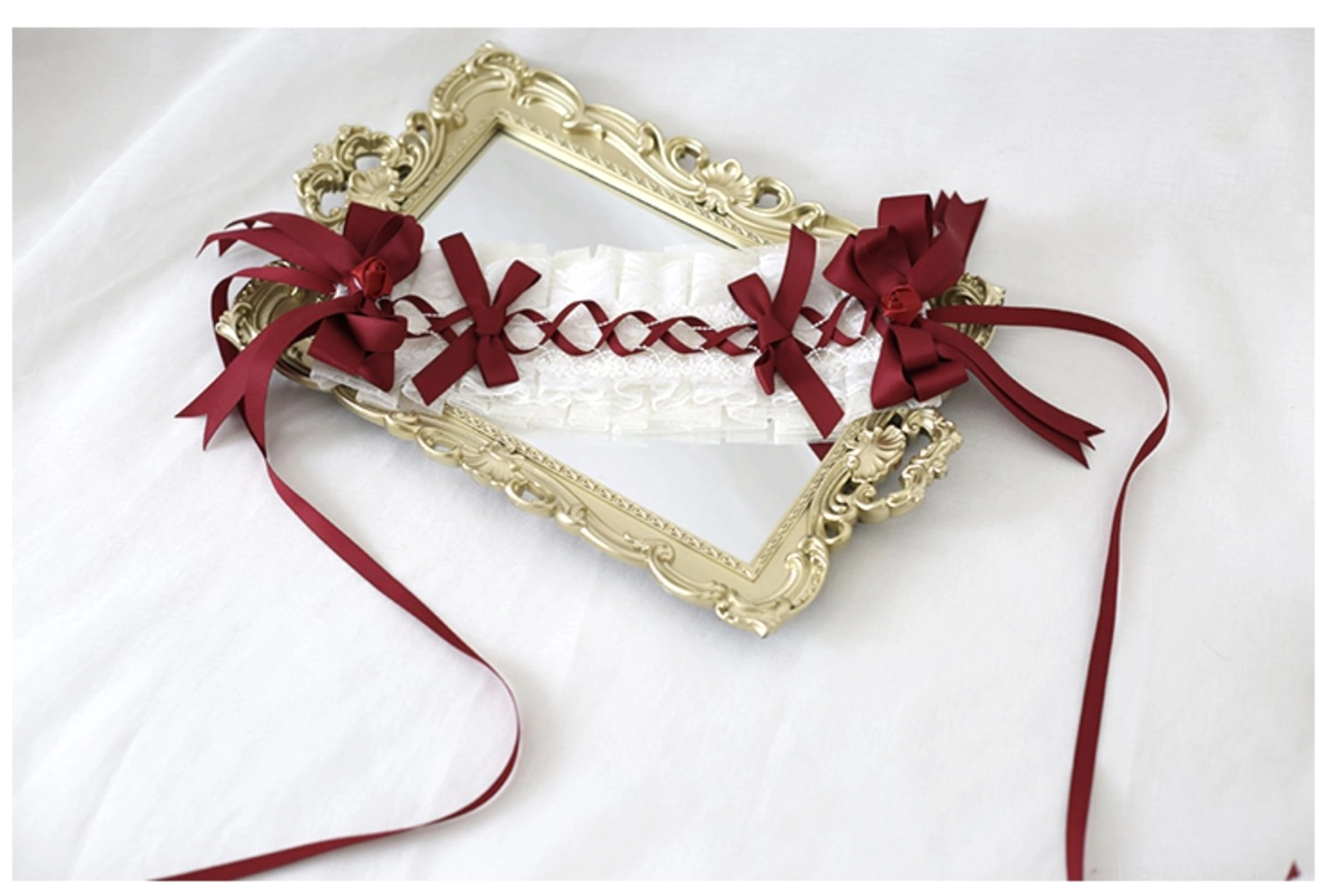 Dark red lolita headdress close-up detail shot showcasing intricate lace craftsmanship wine-red bow construction and delicate embellishments