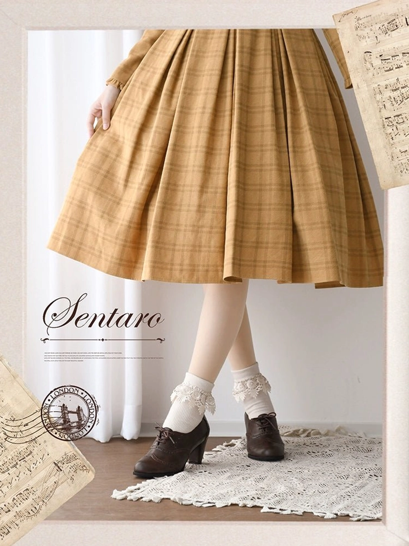 Deep brown smooth lolita leather heel shoes with rounded toe and minimal decorative finish, front view with yellow plaid vintage dress and frilly white ankle socks on crocheted mat