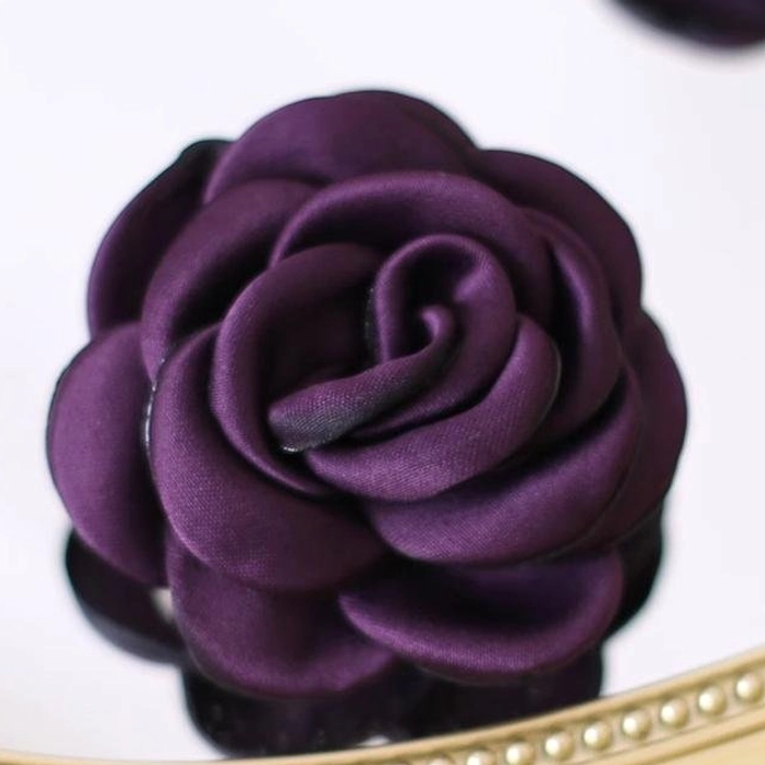 Deep purple fabric rose hair clip and brooch showing handcrafted burnt-edge petal details and pearlescent chiffon material composition