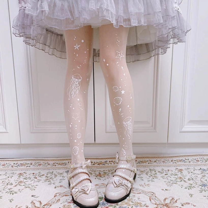 White Deep Sea Jellyfish 20D sheer Lolita tights with delicate jellyfish starfish and shell prints on light base, styled with light gray frilled Lolita skirt and beige bow loafers for summer Lolita wear