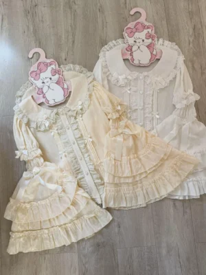 Overhead flat lay of detachable hime sleeves lolita blouse in cream yellow and white with ruffled peter pan collar and tiered trumpet sleeves
