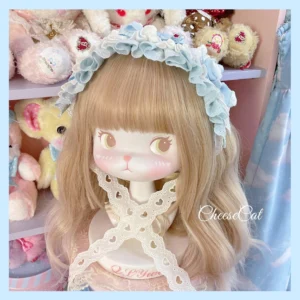 Light blue frilled cotton lolita headdress with white hollow lace overlay and large blue satin bow, displayed on blonde wig doll mannequin with toy shelf backdrop showing sweet doll-inspired aesthetic