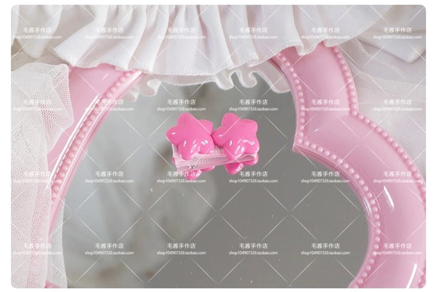 Double pink star hair clip with baby pink glossy star charms and metal clip base on pink heart mirror close-up view
