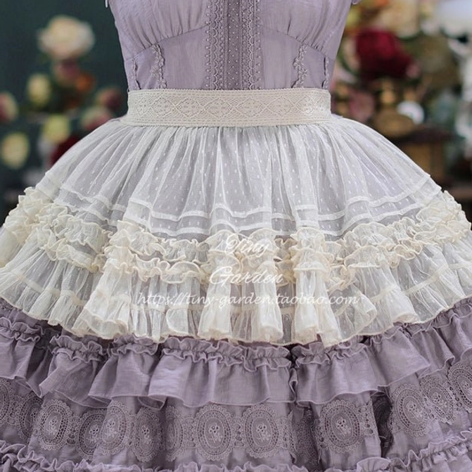 Close-up detail shot of lavender purple lolita dress waist and lower skirt featuring wide lace waist belt, dotted tulle fabric texture, layered ruffled lace trims, and embroidered skirt hem