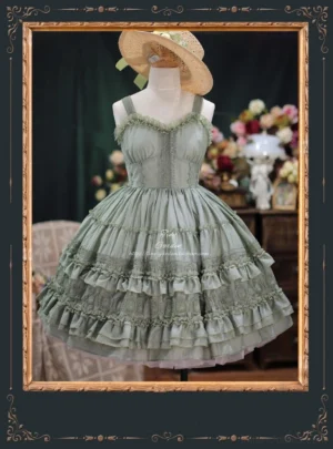 Grayish green French vintage lolita JSK dress with shell-shaped chest design and multi-layered ruffled tulle skirt, worn on dress mannequin with straw boater hat in vintage floral indoor setting