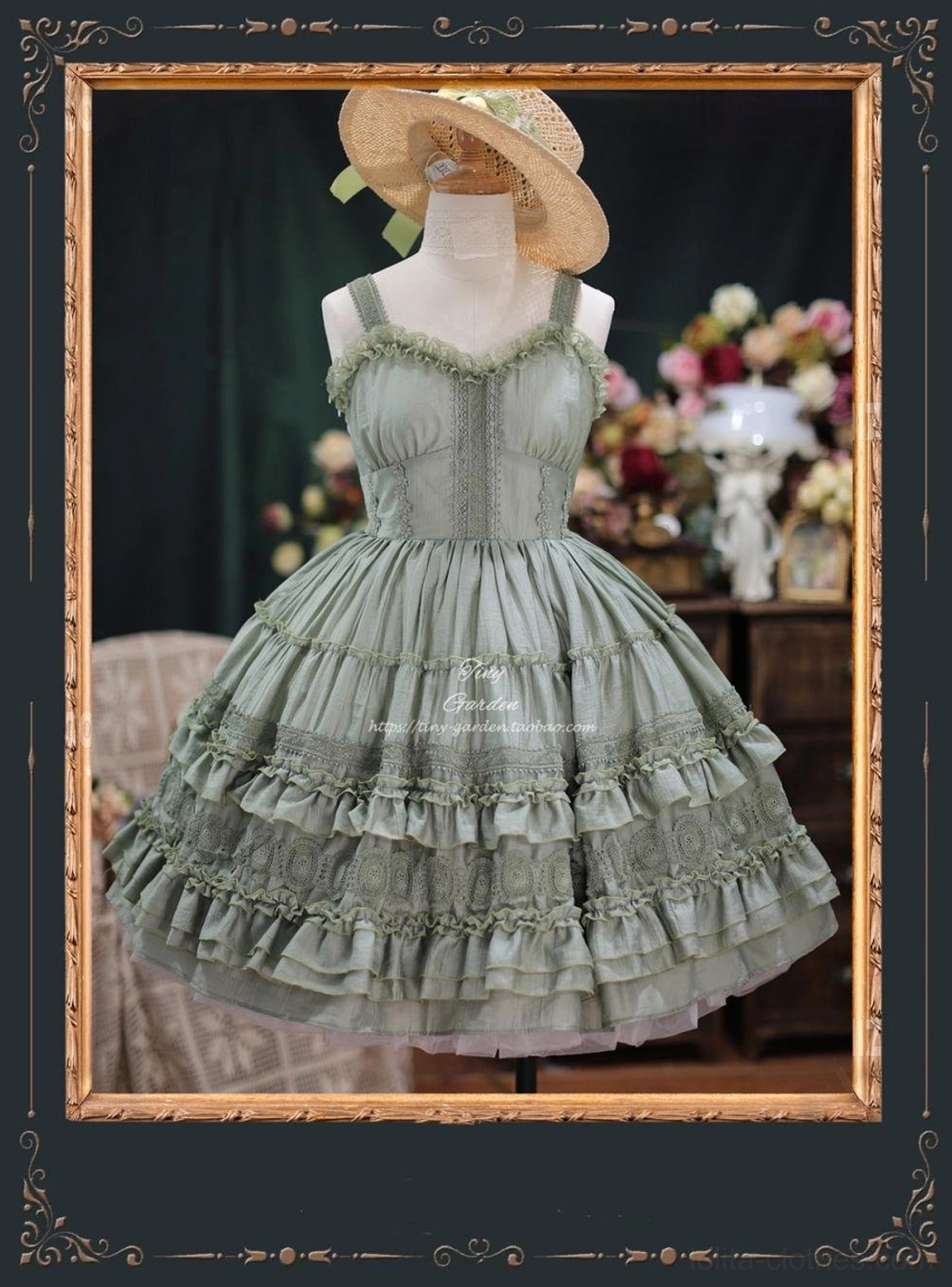 Grayish green French vintage lolita JSK dress with shell-shaped chest design and multi-layered ruffled tulle skirt, worn on dress mannequin with straw boater hat in vintage floral indoor setting
