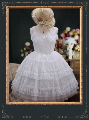 Milk white dotted yarn lolita JSK dress with sweetheart neckline lace edging and tiered ruffled tulle skirt, displayed on mannequin with straw hat and flower adornment against vintage floral backdrop